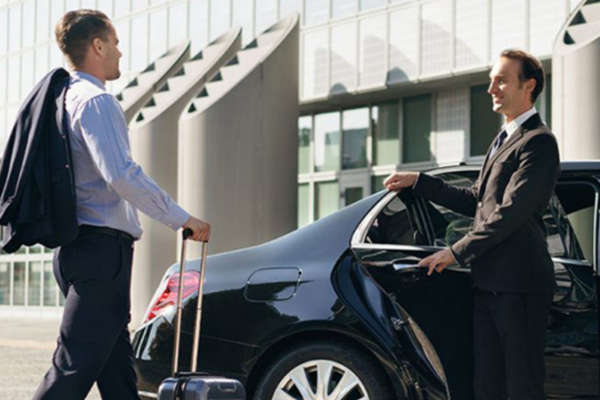 Chauffeur TransfertShuttel ouvrant la portière d'une berline premium à Paris
